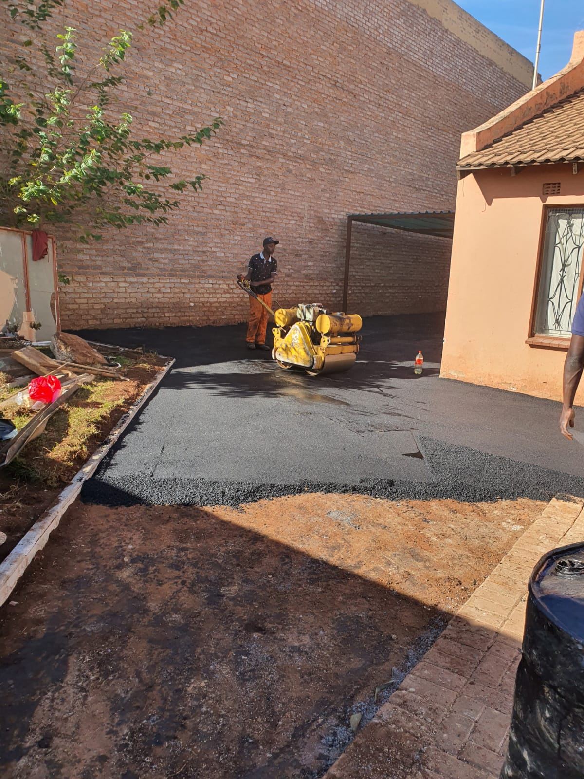 Fresh asphalt surfacing being compacted